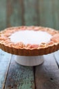 Apple rose pie with cream filling on stand on shabby wood blue b Royalty Free Stock Photo