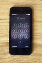 Apple 5 or 5s enter passcode screen on wood Royalty Free Stock Photo