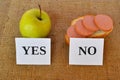 An apple and a sandwich with sausage - useful and harmful snacks