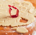 Apple shaped cookie cutter on raw cookie dough.