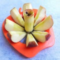 Apple shown beautifully in apple cutter looks like flower shape and it tempts to eat in white background Royalty Free Stock Photo