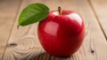 Apple with a single green leaf attached to its stem rests on a Royalty Free Stock Photo