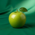 Apple with a single leaf attached sits on a smooth green fabric Royalty Free Stock Photo
