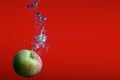 Apple on red background splashing in water fresh bubbles splash fruits Royalty Free Stock Photo