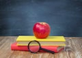 Apple on stack books blackboard background empty space. Royalty Free Stock Photo