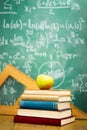 Apple on stack of books with chalkboard Royalty Free Stock Photo