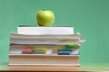 Apple on stack of books in classroom