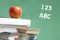 Apple on stack of books in classroom Royalty Free Stock Photo