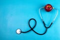 Apple with a stethoscope isolated on blue background. Healthcare And Medicine