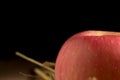 apple. straw. on wood. black background