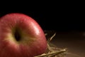 Apple. Straw. On wood. black background