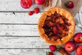 Autumn apple strawberry pie, top view corner border against a white wood background Royalty Free Stock Photo