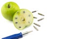 Apple stuck with nails, detail of a fruit with iron, tool