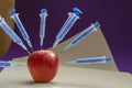 Apple studded with syringes Royalty Free Stock Photo