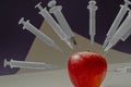 Apple studded with syringes Royalty Free Stock Photo