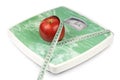 Apple and tape measure on a scale Royalty Free Stock Photo