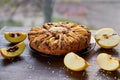 Apple tart with quince, poppy seeds, raisins and sesame on wooden brown table. Apple pie decorated with sliced fresh quince, apple