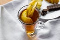 Apple tea in a transparent glass with a handle, the drink is decorated with slices of fresh apple with a yellow peel, next to the Royalty Free Stock Photo