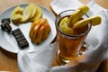 Apple tea in a transparent glass with a handle, the drink is decorated with slices of fresh apple with a yellow peel, next to the Royalty Free Stock Photo