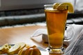 Apple tea in a transparent glass with a handle, the drink is decorated with slices of fresh apple with a yellow peel, next to the Royalty Free Stock Photo