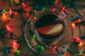 Apple tea on a wooden table in glass cup among garland Royalty Free Stock Photo