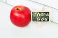 Apple with a Thank you inscription on a wooden Board black background