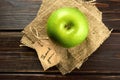 Apple with thank you lable on a piece of burlap over dark wooden background. Happy thanksgiving day concept. Top view