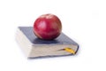 Apple on top of the old book on the white. Royalty Free Stock Photo