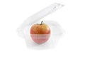 Apple in a transparent plastic container isolated on a white background. Capacity for products. Royalty Free Stock Photo