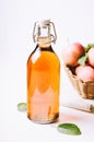 Apple vinegar in a bottle on white wooden table with apples in a basket. Royalty Free Stock Photo