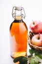 Apple vinegar in a bottle on white wooden table with apples. Rustic style. Royalty Free Stock Photo