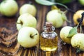 Apple vinegar in glass jar with ripe green fruit. Bottle of apple organic vinegar on wooden background. Healthy organic food.