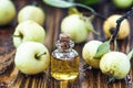 Apple vinegar in glass jar with ripe green fruit. Bottle of apple organic vinegar on wooden background. Healthy organic food.