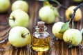 Apple vinegar in glass jar with ripe green fruit. Bottle of apple organic vinegar on wooden background. Healthy organic food.