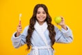 Apple vitamins for healthy teeth. Teenager girl brushing her teeth over yellow background. Daily hygiene teen