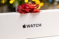 Apple watch box with a red bow against blurred backround. Royalty Free Stock Photo