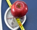 Apple on Weighing machine with inch tape, concept of eating healthy and maintaining good Body Mass Index