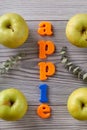 Apple word and green apples on grey table. Royalty Free Stock Photo