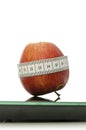 Apple wrapped with measuring tape on a scale