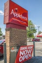 Applebees bar and grill restuarant street sign now open