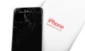 AppleCare service box and broken iPhone, cracked screen. Apple is a multinational technology company Royalty Free Stock Photo