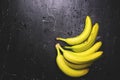 Apples and bananas on a dark background with splashes of water.