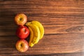 Apples and bananas kept on a wooden table with copy apace