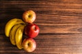 Apples and bananas kept on a wooden table with copy apace