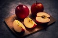 Apples board. Apples are on a cutting board and one apple is cut into a several pieces and the whole composition on a dark