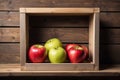 Apples in a box on a wooden shelf. A framework on a wooden background Royalty Free Stock Photo