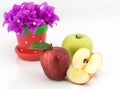 Apples, half of apple and bougainvillea flower in small pot Royalty Free Stock Photo