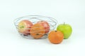 Apples and oranges in a decoratively wire basket put on isolated white background with clipping path. Royalty Free Stock Photo