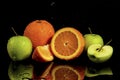 Apples and oranges fruits with drops and splashes of water on a black background Royalty Free Stock Photo