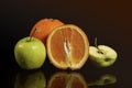 Apples and oranges fruits with drops and splashes of water on a black background Royalty Free Stock Photo